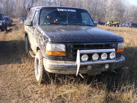 1996 Ford Bronco - Muddy 1996 Ford Bronco with a light bar and 'REDNECK-OFFROAD' sticker on the windshield.
