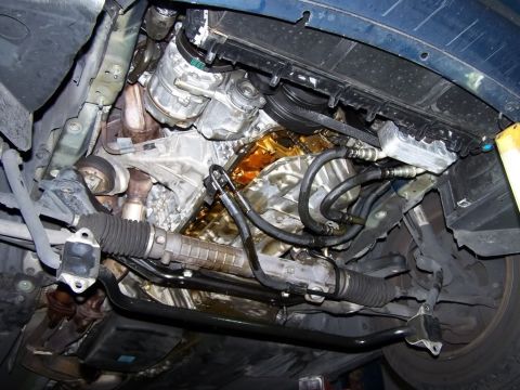 1999 BMW 5 Series - Underside view of a vehicle's engine bay, revealing the steering rack and various engine components.