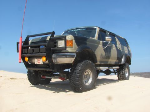 1996 Ford Bronco - This lifted Ford Bronco features a camouflage paint job and a heavy-duty bull bar, ready for off-road adventure.