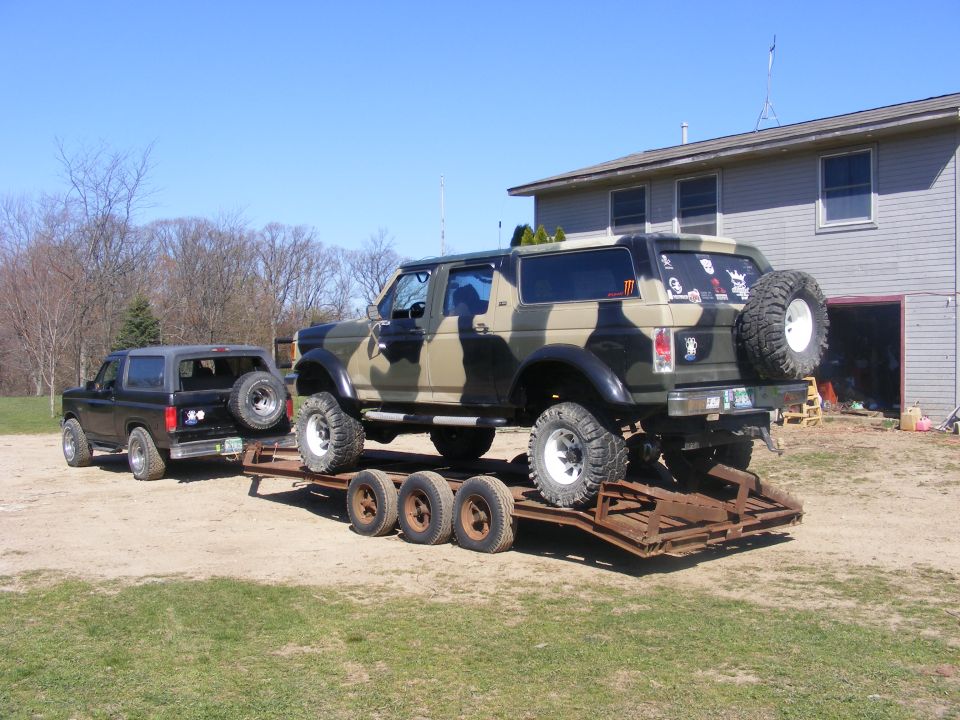 1996 Ford Bronco on trailer, another black Bronco parked nearby