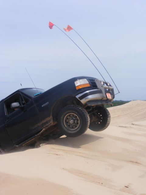 1996 Ford Bronco - Ford Bronco navigating sand dunes under a clear sky.