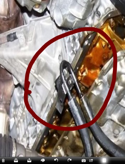 1999 BMW 5 Series - A red circle highlights an oil leak on the engine block of a vehicle.