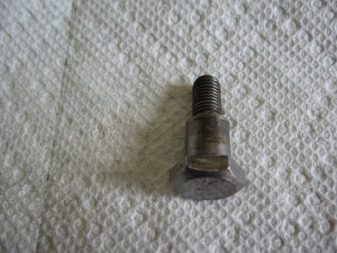 1994 Ford Bronco - A single metal bolt rests on a textured white surface.