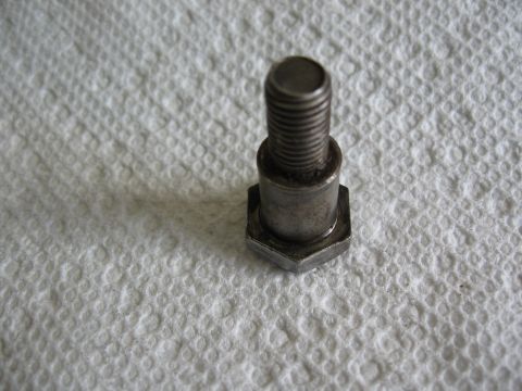 1994 Ford Bronco - A single metal bolt with a hexagonal head and threaded shaft is shown on a white textured surface.