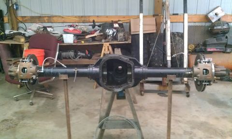 1995 Ford Bronco - Ford Dana 50 front axle assembly, likely for a truck or SUV, is shown disassembled in a workshop.