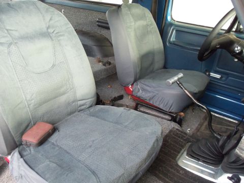 1985 Ford Bronco - The interior of this vehicle shows a floor shifter and two front seats with covers.