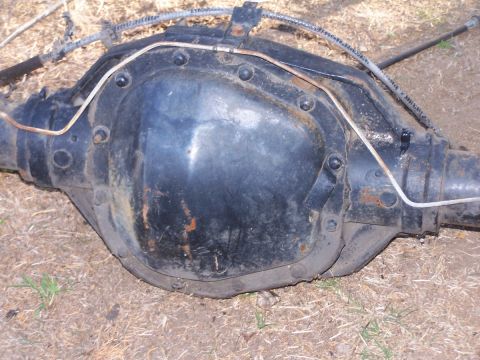 1990 Ford Bronco - A rear axle differential, likely from an older vehicle, is shown resting on the ground.