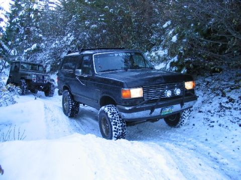 1988 Ford Bronco - A black 1988 Ford Bronco navigates a snowy path, with a Jeep following closely behind on the winter trail.