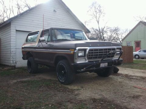 1979 Ford Bronco - This 1979 Ford Bronco is parked outside a garage, a two-tone paint scheme and off-road modifications.