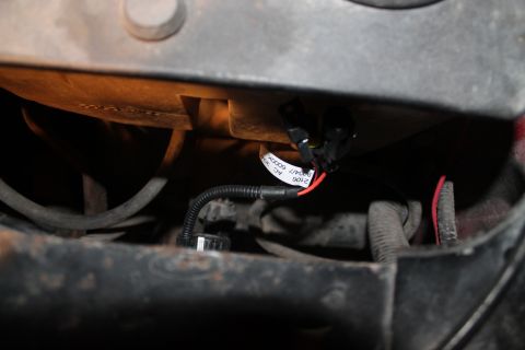 1990 Ford Bronco - A close-up view of a vehicle's wiring harness, showing a label with product information.