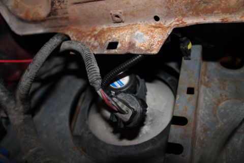 1990 Ford Bronco - Detail of automotive wiring and a headlight assembly, showing signs of rust and wear.