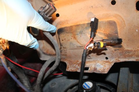 1990 Ford Bronco - Close-up of electrical connections being made to a vehicle's frame, with the SuperMotors logo in the corner.