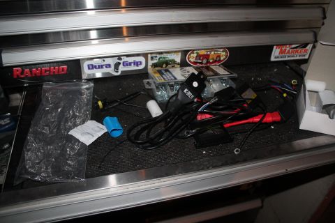 1990 Ford Bronco - Contents of a tool drawer, including wiring and various automotive-themed stickers.
