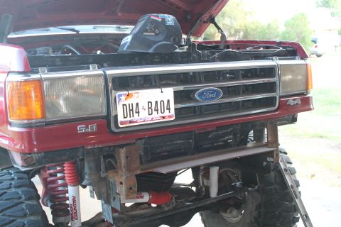 1990 Ford Bronco - Front view of a red 1990 Ford Bronco, showing the grille, headlights, and a custom bumper modification.