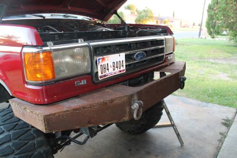 1990 Ford Bronco - This Ford truck features a custom bumper and the hood is up, revealing the engine bay.