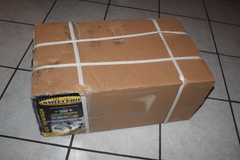 1990 Ford Bronco - A cardboard box containing a Smittybilt winch is secured with white strapping.