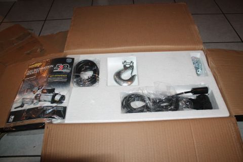 1990 Ford Bronco - Unboxed winch and associated parts, including a hook and cables, with an instruction booklet visible.