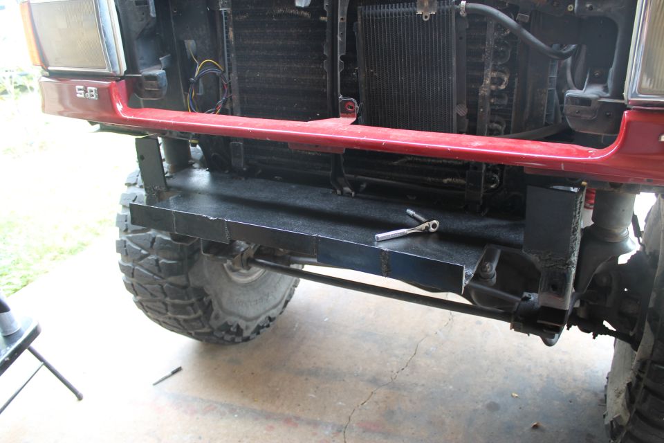 1990 Ford Bronco front end with custom bumper fabrication, showing red fender and large tire