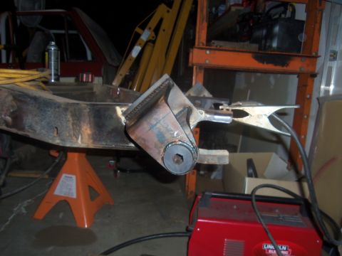 1968 Ford Bronco - A vehicle frame is being worked on with welding equipment and is supported by jack stands in a workshop.