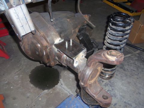 1968 Ford Bronco - Close-up of a vehicle's differential and suspension components, with a coil spring visible.