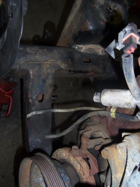 1968 Ford Bronco - This image shows the underside of a vehicle, focusing on the frame and engine components with visible rust and wear.