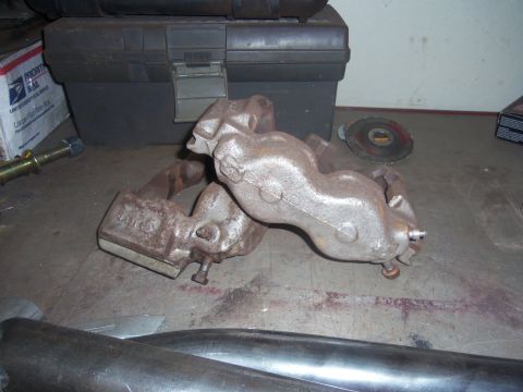 1968 Ford Bronco - These rusty exhaust manifolds are shown on a workbench, possibly for a Ford Bronco project.