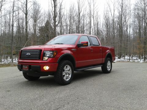 1978 Ford F-150 - This red pickup truck features a distinctive black grille and fender flares, captured from a 3/4 front angle.