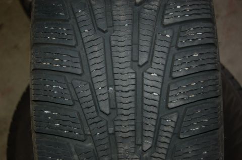 2000 Subaru Forester - A tire tread pattern is visible, with numerous small white particles lodged within its grooves.