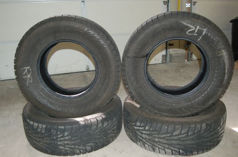 2000 Subaru Forester - A set of four tires, two of which have handwritten labels 'RR' and 'LR' on them.