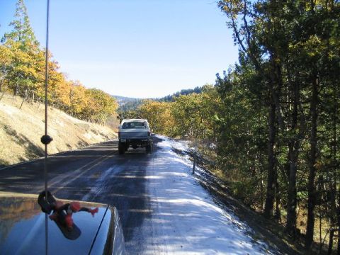 1988 Ford Bronco - Driving on a wet road with autumn foliage and snow on the side.