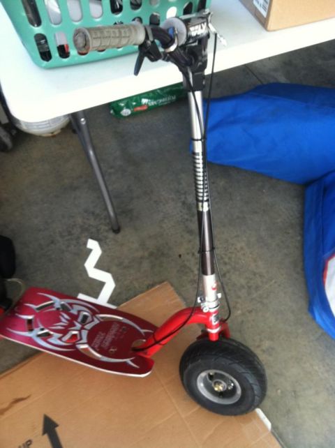 1978 Ford Bronco - A red electric scooter with a decorative deck is shown in a garage setting.