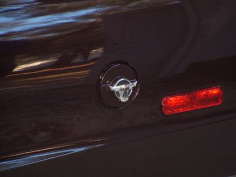 1972 Ford Ranchero - Close-up of a vehicle's rear quarter panel showing a distinctive emblem and a red taillight.