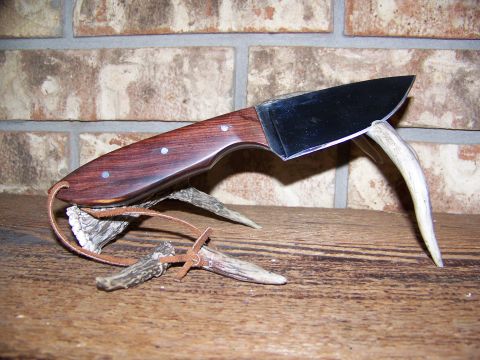2000 Jeep Wrangler - Knife with wooden handle and metal blade, displayed on antlers against a brick wall.