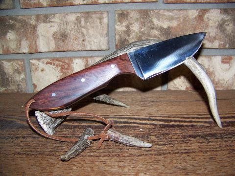 2000 Jeep Wrangler - A knife with a polished metal blade and a dark wood handle is displayed on a pair of antlers.