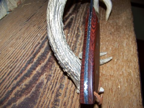 2000 Jeep Wrangler - A knife with a wooden handle and layered steel blade is shown against a rustic background with an antler.