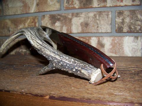 2000 Jeep Wrangler - Knife with wooden handle and leather loop rests on a deer antler. Supermotors.net logo is in the corner.
