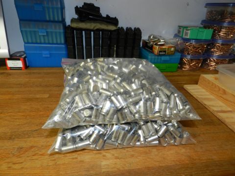 1996 Ford Bronco - A large quantity of spent shell casings are stored in plastic bags, with ammunition storage containers in the background.