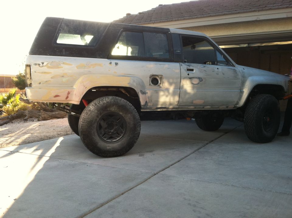 Toyota 4Runner in primer, side view, with aftermarket wheels and suspension