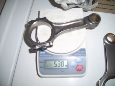 1995 Ford Probe - A close-up shows an engine connecting rod being weighed on a digital scale, displaying 538 grams.