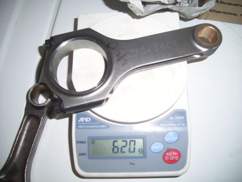 1995 Ford Probe - A metal connecting rod is weighed on a digital scale.