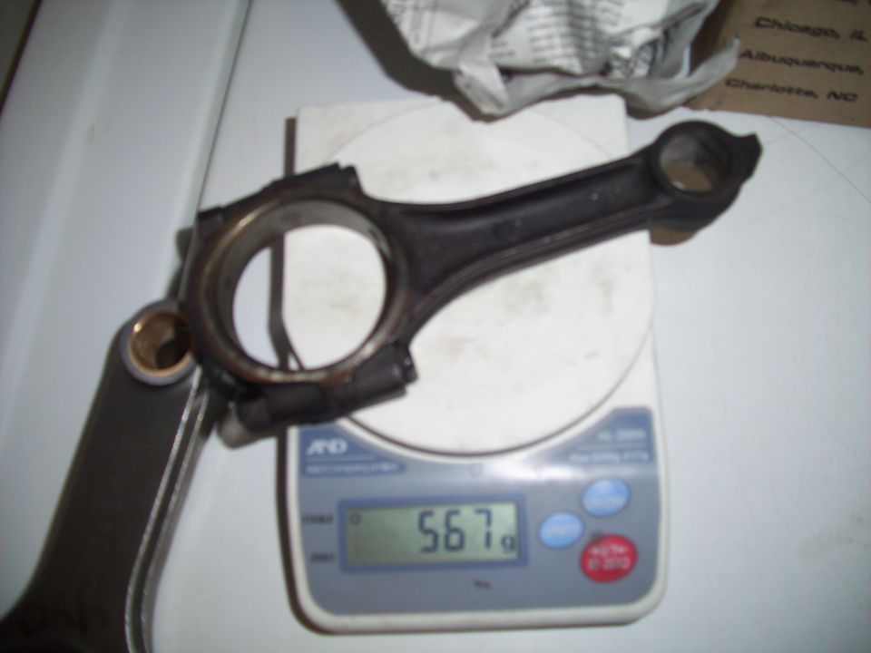 Connecting rod on scale showing 567g