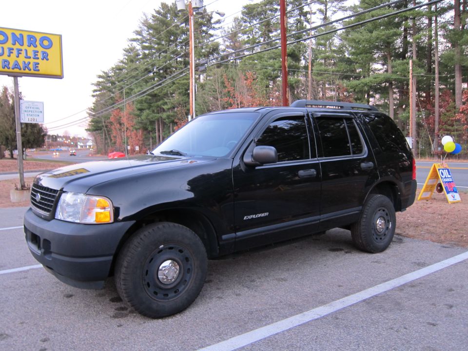 Black Ford Explorer parked in a lot, 3/4 front view