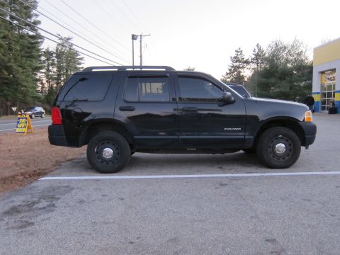 1991 Ford LTD Crown Victoria - A black Ford Explorer is parked in a lot near a road with a state safety inspection sign visible.