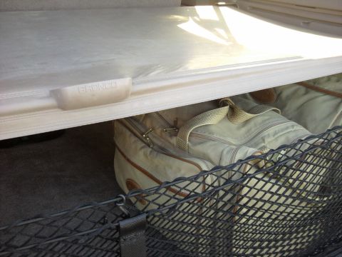1994 Ford Bronco - The cargo area of a vehicle contains luggage and a net, with a handle labeled 'BRONCO'.