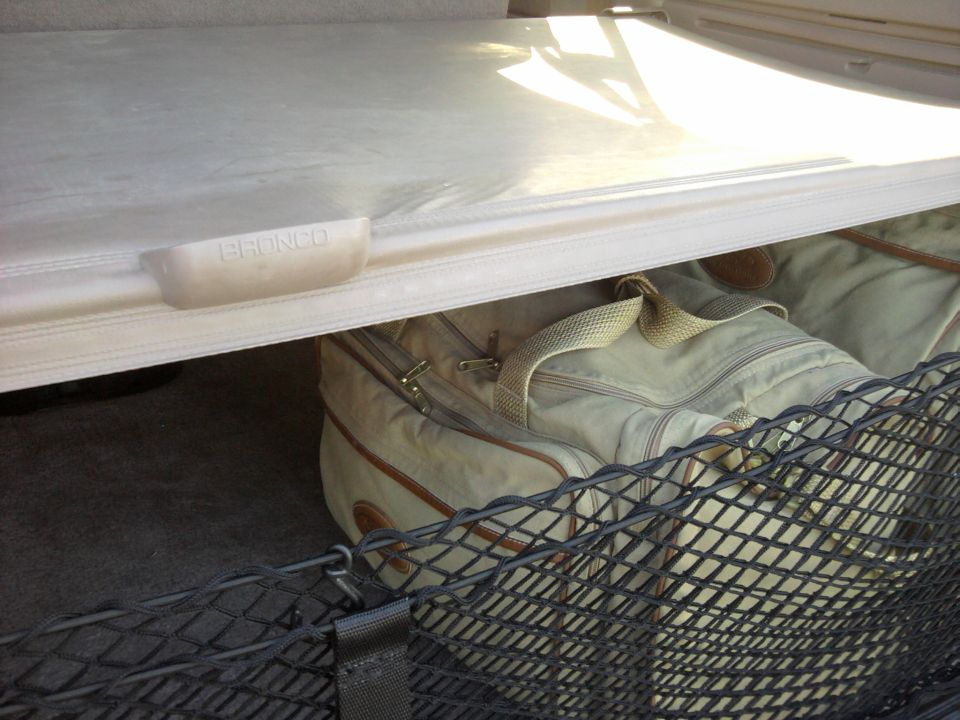 Cargo area with a bag and a net, and a handle with 'BRONCO' embossed on it