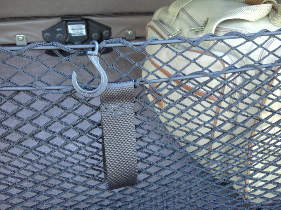 Gray elastic cargo net with metal S-hook strap in a vehicle cargo area
