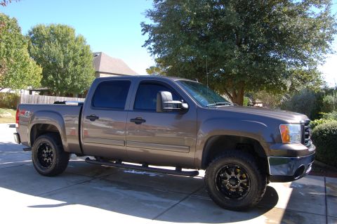 2007 GMC Sierra 1500 - A gray 2007 GMC Sierra 1500 pickup truck is parked in a driveway on a sunny day.