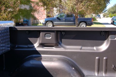 2007 GMC Sierra 1500 - A dark blue pickup truck is parked on the street, seen from the perspective of its own truck bed.