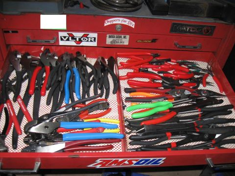 2000 Ford Crown Victoria - A red Matco tool chest drawer is organized with an assortment of pliers, including red, blue, and green handled tools.