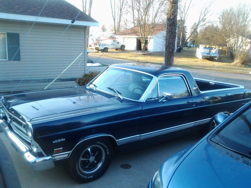 Dark blue 1967 Ford Ranchero parked next to a blue car. Visible badge reads '289'
